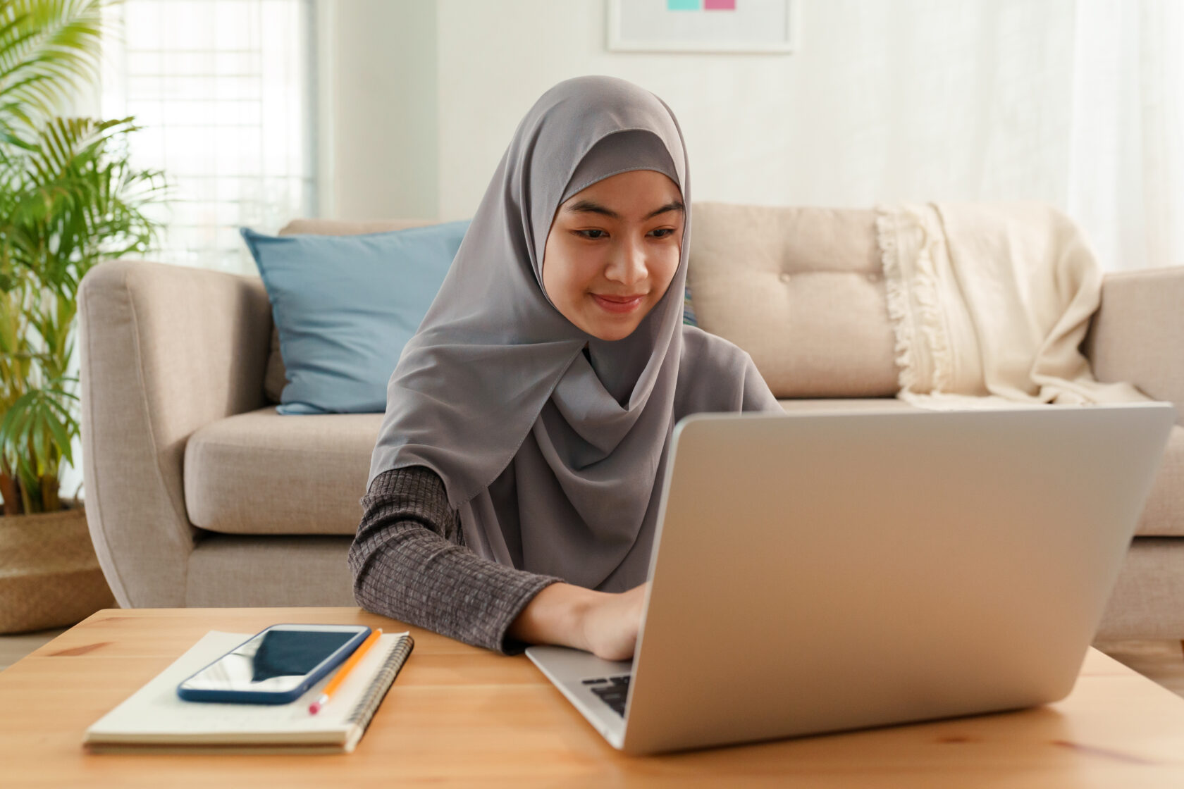 Muslim young women wear hijab using computer laptop typing work at home